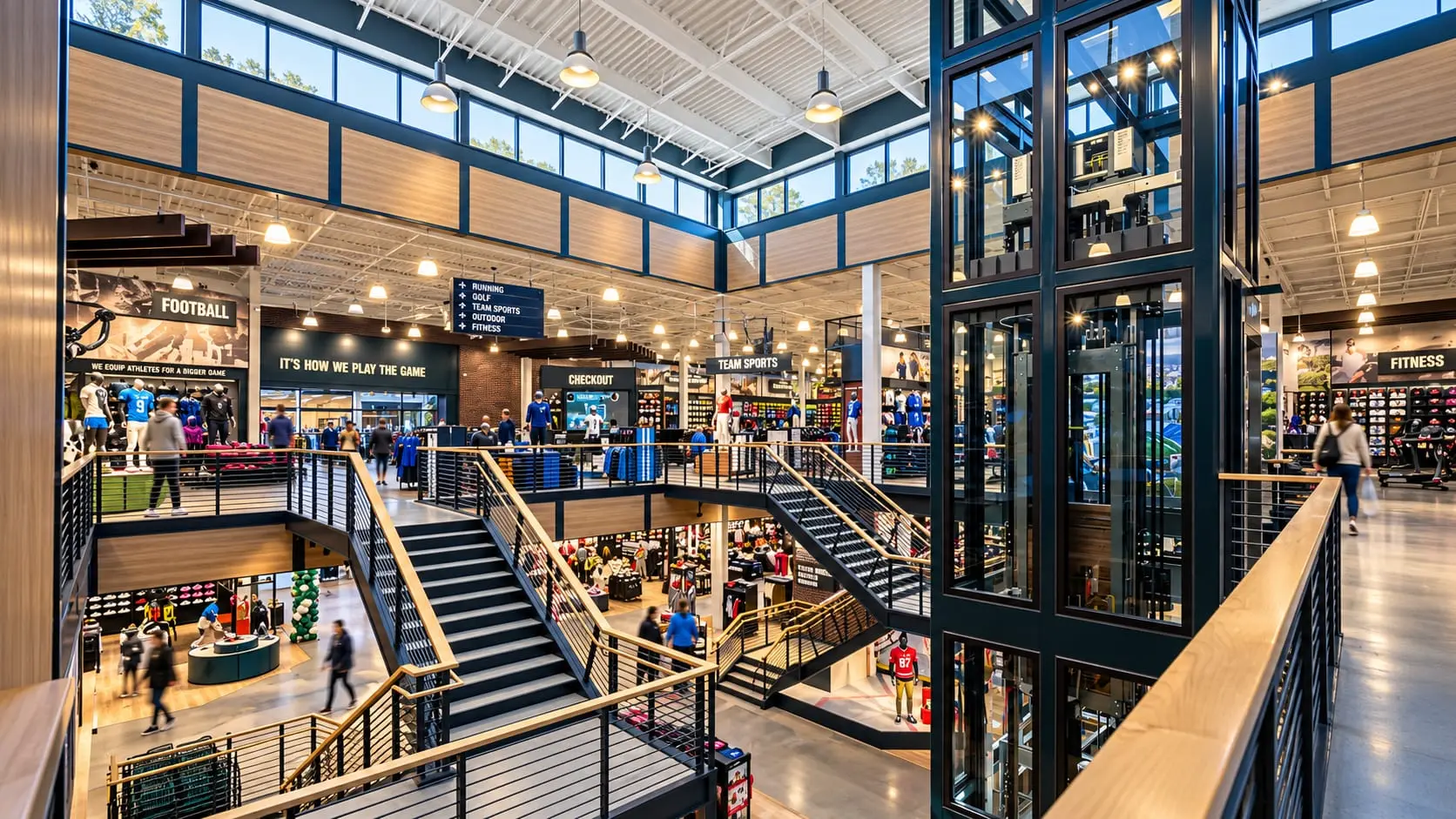 Inside Dick's House of Sport: open staircases and a glass elevator between the ground and second floors, under clerestory windows